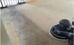 Tufts technician cleaning carpet in a commercial building